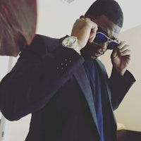 a man wearing a suit and sunglasses